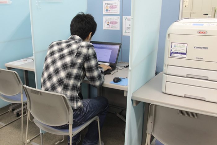パソコンに向かって書類を作成する男性